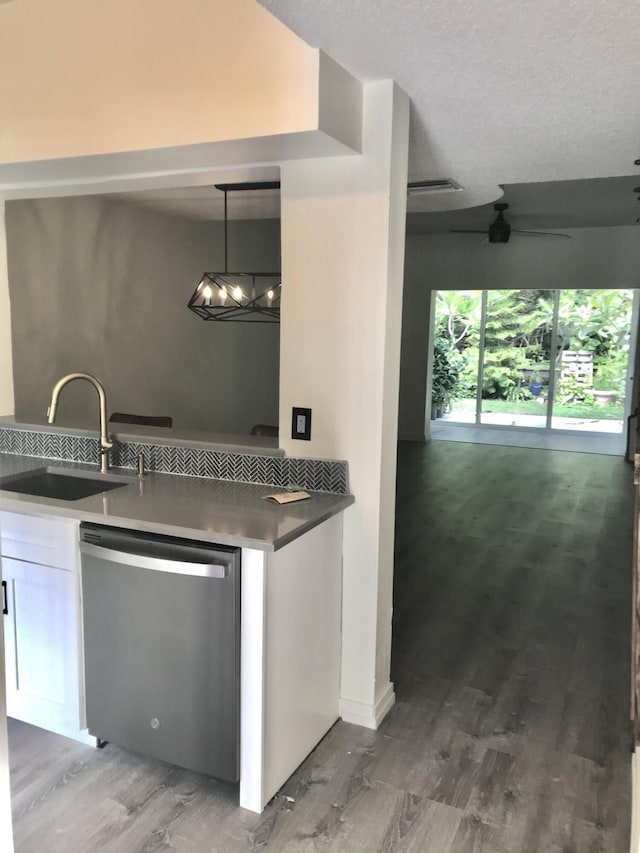 kitchen with white cabinets, dishwasher, wood finished floors, decorative light fixtures, and a sink