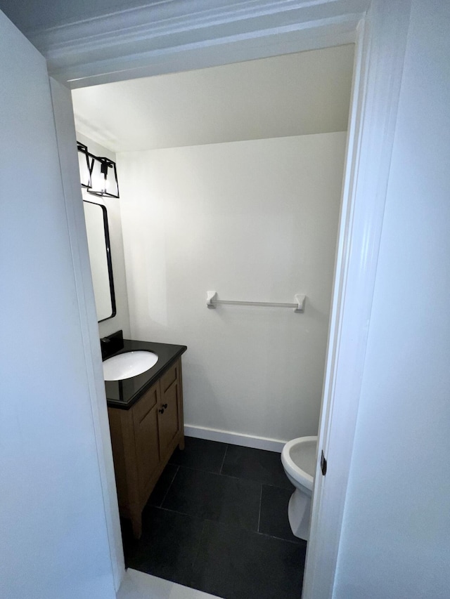 half bath with vanity, baseboards, and tile patterned floors