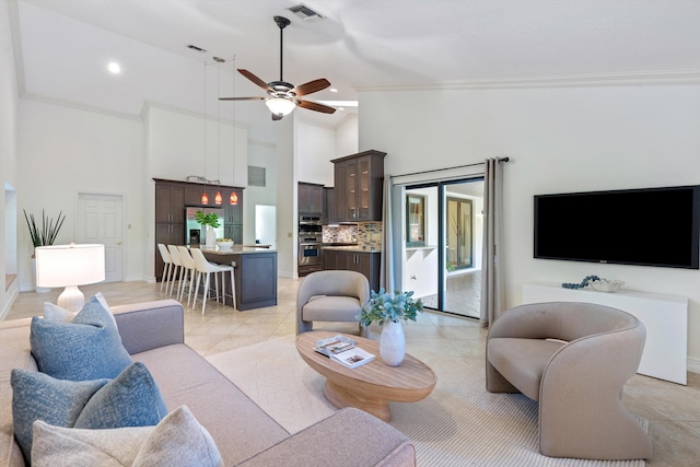 living area with light tile patterned floors, visible vents, ceiling fan, and ornamental molding