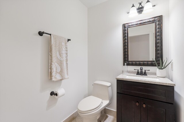 bathroom with vanity, toilet, and baseboards