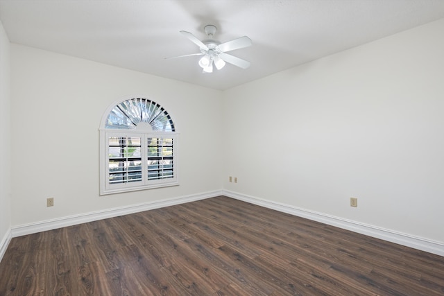 empty room featuring a ceiling fan, dark wood-style floors, and baseboards