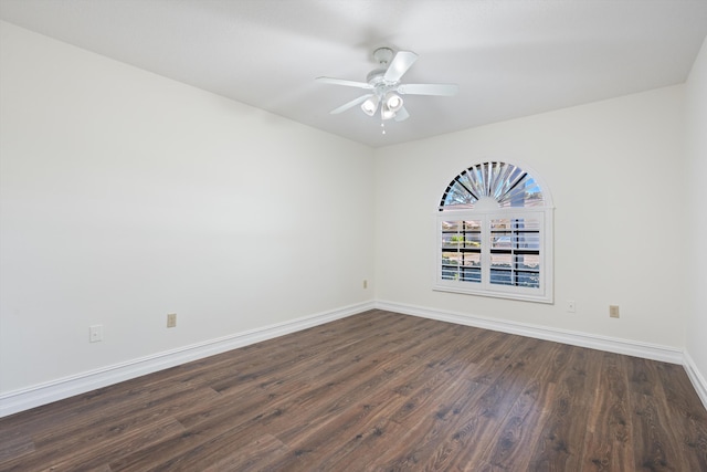empty room featuring dark wood-style floors, ceiling fan, and baseboards
