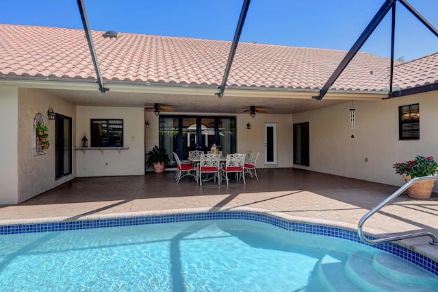 outdoor pool with a patio area, outdoor dining space, a lanai, and a ceiling fan