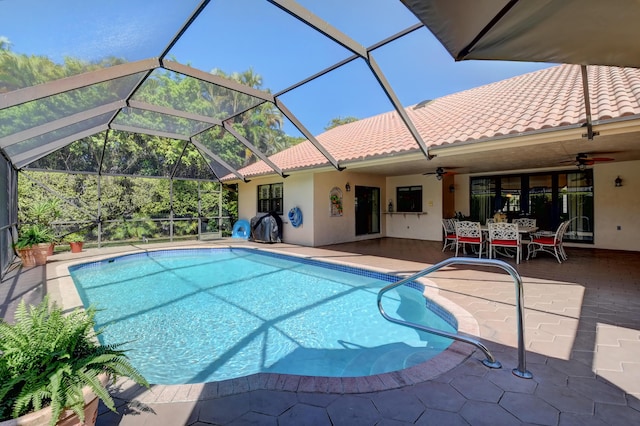 outdoor pool featuring glass enclosure, a patio, and ceiling fan