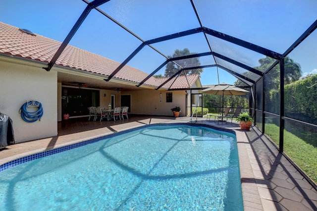 pool featuring glass enclosure, outdoor dining area, and a patio area