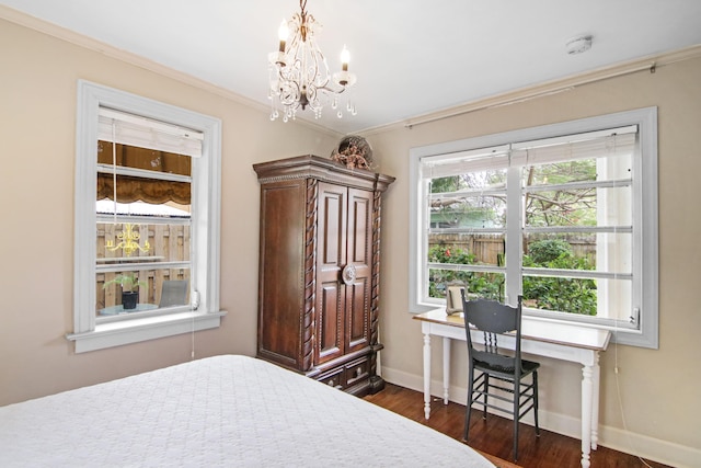 bedroom with dark wood-type flooring, a chandelier, crown molding, and baseboards