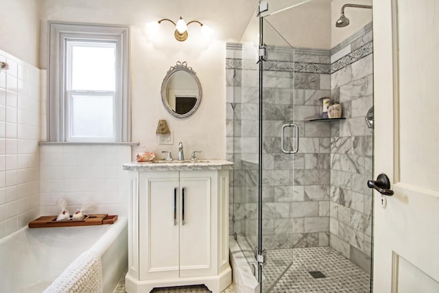 full bathroom featuring a shower stall, vanity, and a bath