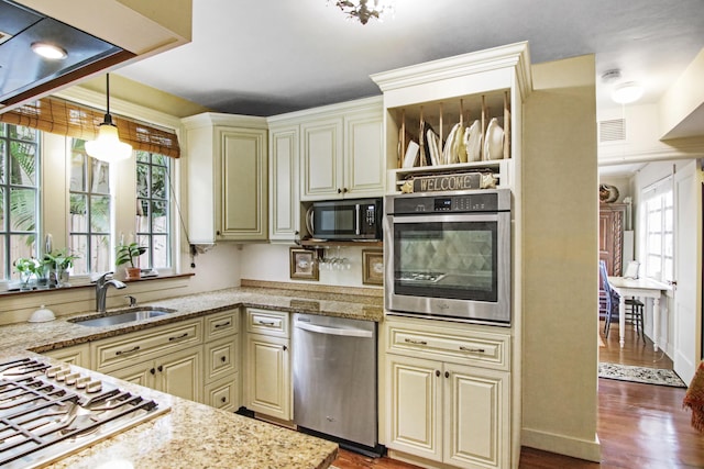 kitchen with visible vents, dark wood-style floors, cream cabinets, stainless steel appliances, and a sink