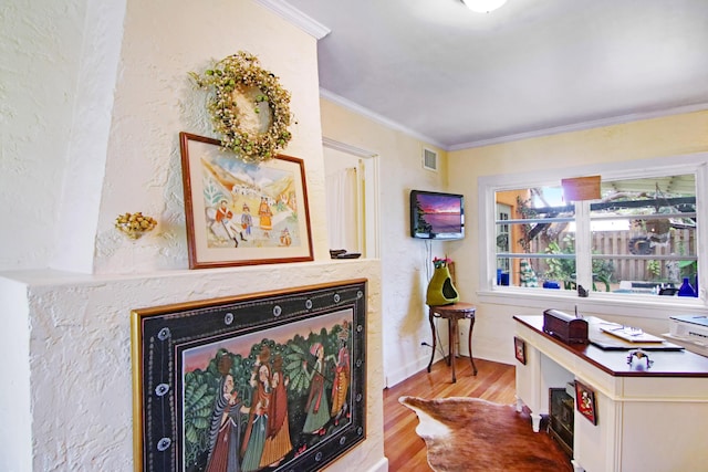 interior space with visible vents, ornamental molding, and wood finished floors