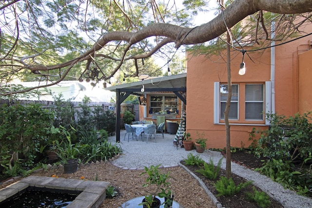 exterior space featuring a patio, fence, and stucco siding