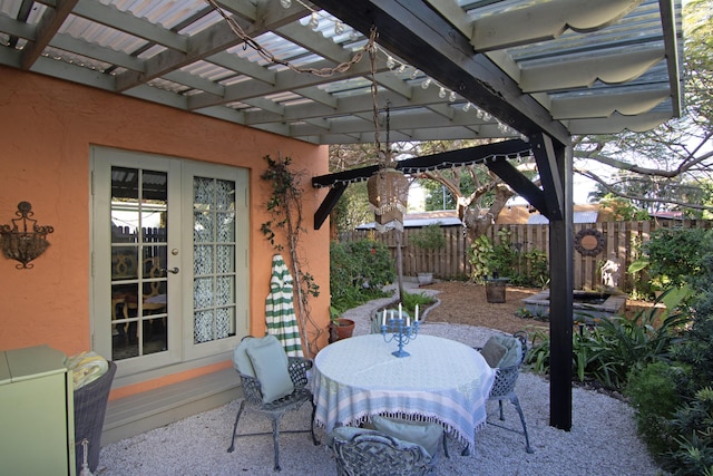 view of patio with french doors, fence, outdoor dining area, and a pergola