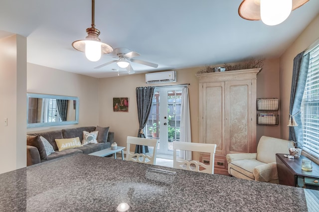 interior space with french doors, ceiling fan, and a wall mounted AC