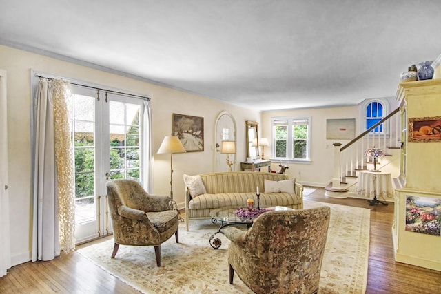 living area featuring stairway, baseboards, and wood finished floors