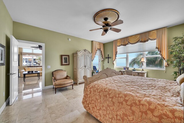 bedroom featuring marble finish floor, a ceiling fan, and baseboards