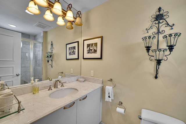 full bathroom with a chandelier, toilet, visible vents, vanity, and a stall shower