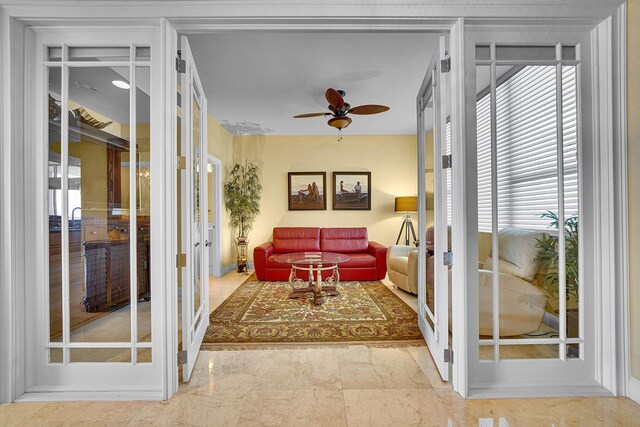 sunroom featuring a ceiling fan and french doors