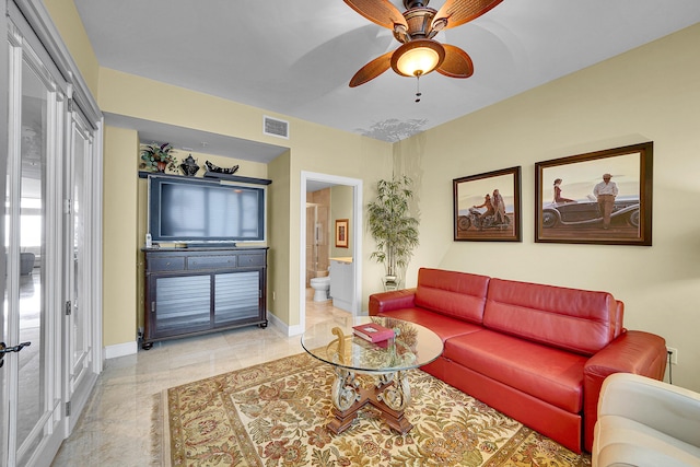 living area featuring baseboards, visible vents, and ceiling fan