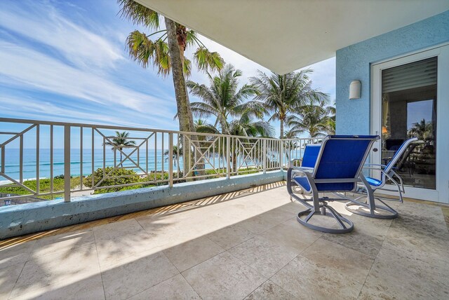 view of patio featuring a water view and a balcony