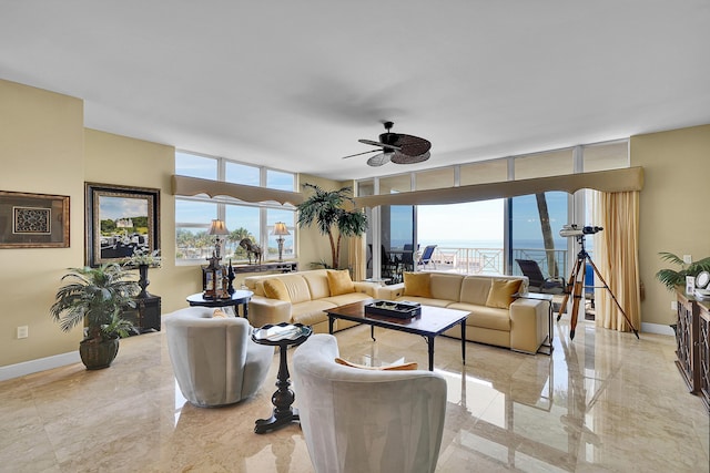 living area featuring marble finish floor, plenty of natural light, and baseboards