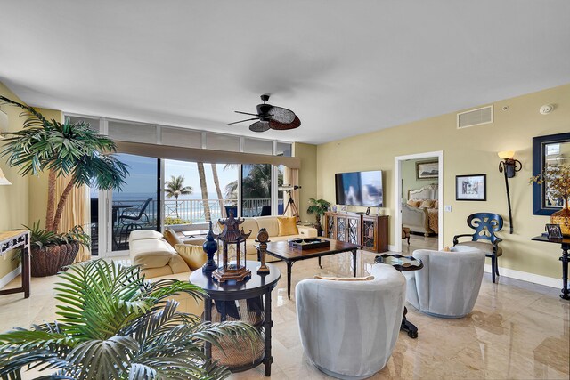 living area with marble finish floor, baseboards, visible vents, and a ceiling fan