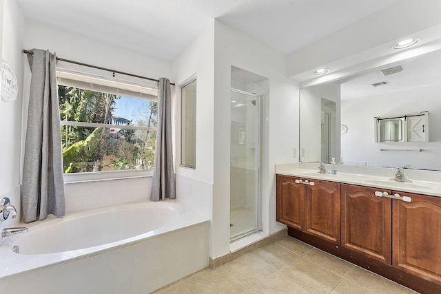 full bathroom with a sink, a garden tub, a shower stall, and tile patterned flooring