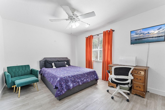 bedroom featuring light wood-type flooring, baseboards, and a ceiling fan