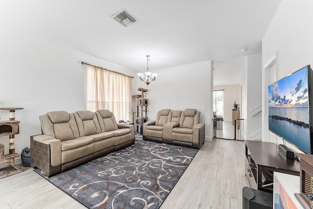 living room featuring an inviting chandelier, visible vents, and wood tiled floor