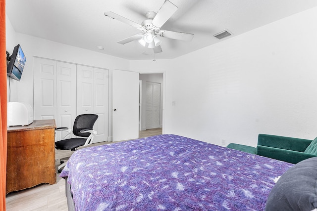 bedroom with a closet, visible vents, light wood-style flooring, and ceiling fan