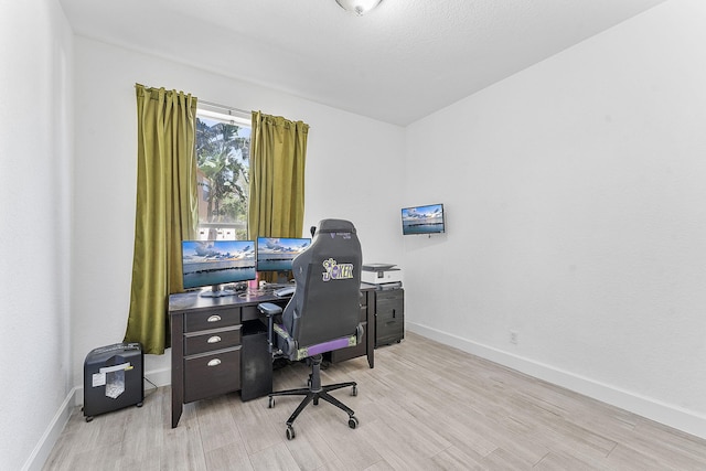 office space featuring baseboards and light wood finished floors