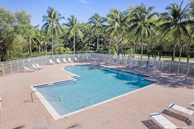 pool with a patio and fence