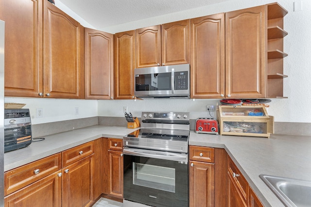 kitchen with open shelves, stainless steel appliances, brown cabinets, and light countertops