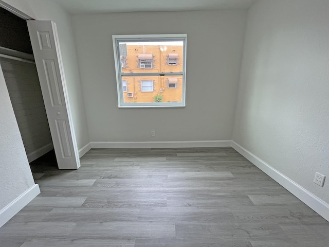 unfurnished bedroom with baseboards and wood finished floors