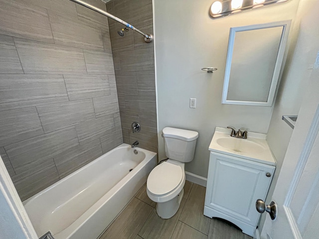 bathroom with wood finish floors, shower / bathtub combination, toilet, vanity, and baseboards