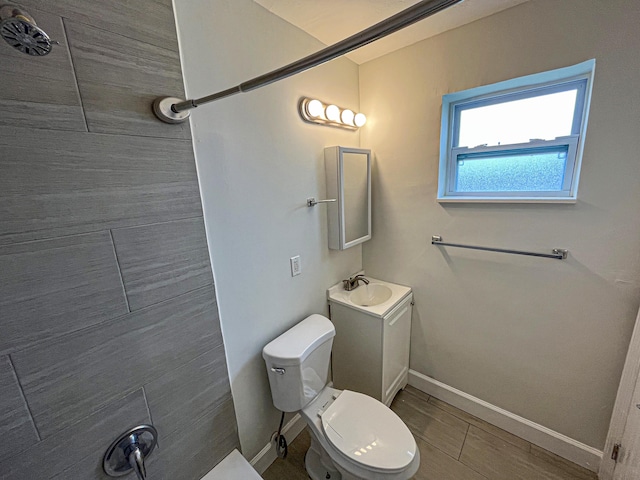 bathroom featuring wood finished floors, vanity, toilet, and baseboards