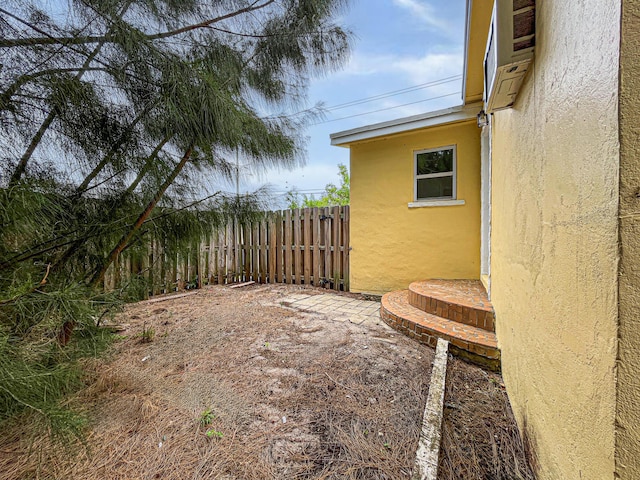 view of yard with fence and a wall mounted AC