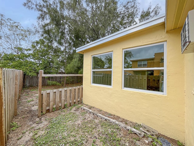 view of side of property with a fenced backyard and stucco siding