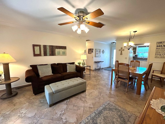 living room with baseboards, crown molding, and ceiling fan with notable chandelier