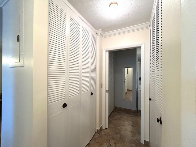 corridor featuring a textured ceiling and ornamental molding