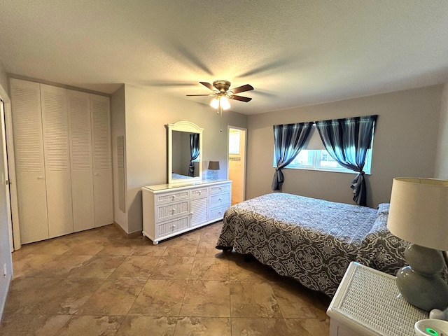 bedroom with ceiling fan and a textured ceiling