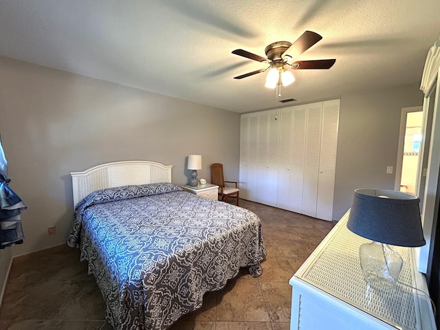 bedroom featuring a textured ceiling, a closet, visible vents, and a ceiling fan