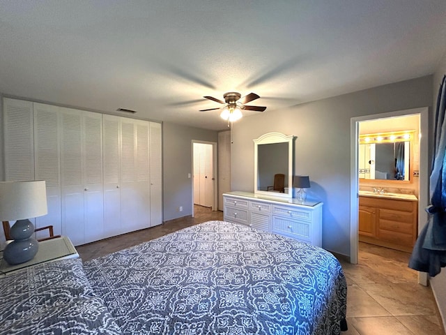 bedroom featuring a ceiling fan, connected bathroom, visible vents, and a sink