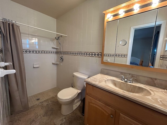 full bathroom featuring tile walls, a tile shower, vanity, and toilet