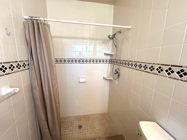 bathroom featuring a stall shower and toilet