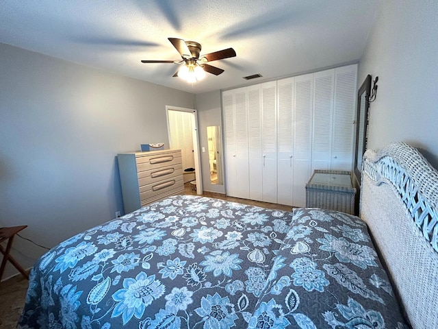 bedroom featuring ceiling fan, visible vents, and a textured ceiling