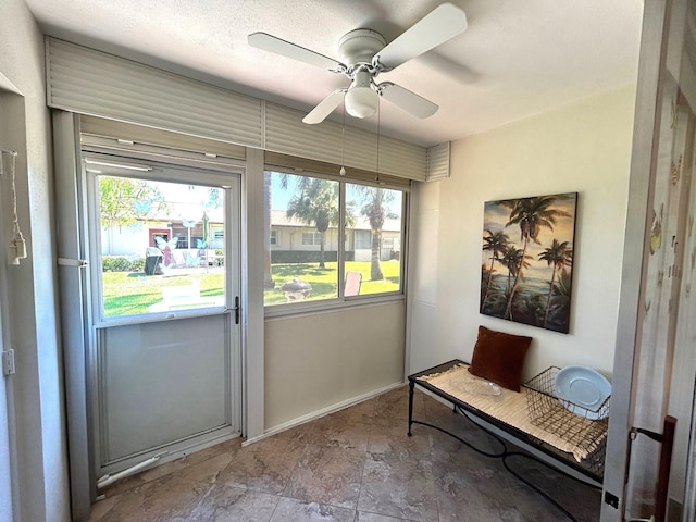 entryway with a ceiling fan and baseboards