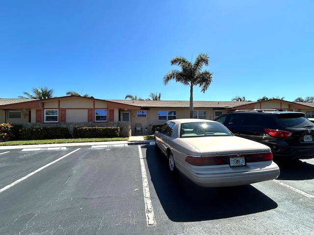 view of front of property with uncovered parking and stucco siding