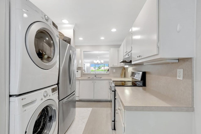 washroom with stacked washer and clothes dryer, a sink, recessed lighting, a chandelier, and laundry area