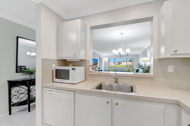 kitchen with crown molding, a chandelier, light countertops, white appliances, and a sink