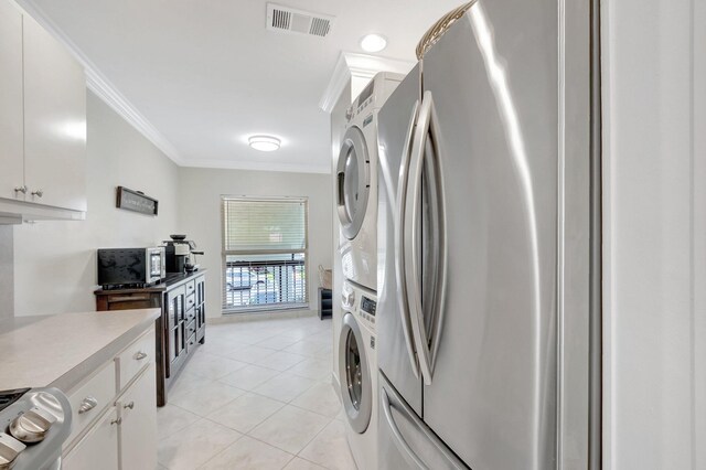 laundry room with visible vents, light tile patterned flooring, crown molding, stacked washer / drying machine, and laundry area