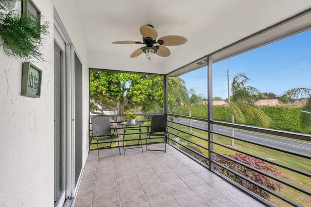 unfurnished sunroom featuring ceiling fan